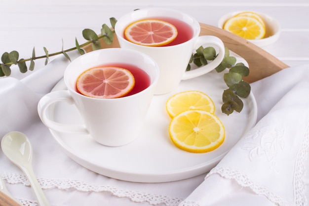 Dos tazas de frutos rojos y té de hierbas con rodaja de limón, vista superior