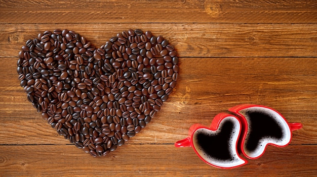 Dos tazas y granos de café en forma de corazón sobre un fondo de madera. Día de San Valentín, Ilustración de renderizado 3D.