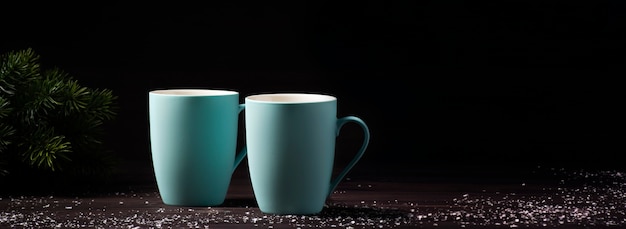 Foto dos tazas de madera, espolvoreadas con nieve