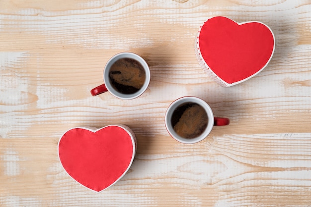 Dos tazas rojas de café y cajas en forma de corazón. Fecha, día de San Valentín. Vista superior