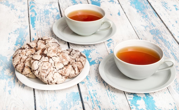 Dos tazas de té con galletas en la mesa