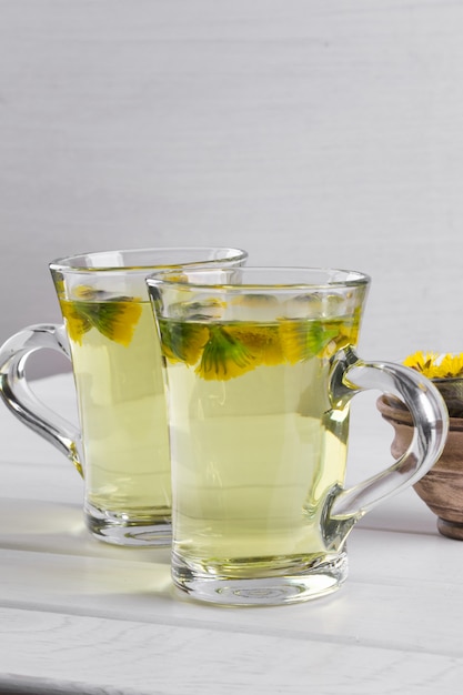 Foto dos tazas de té de hierbas con flores de coltsfoot (o tussilago)