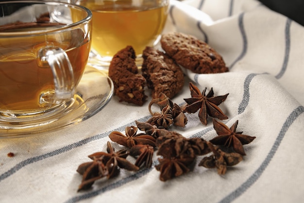 Dos tazas de té de hierbas y galletas en un paño de cocina