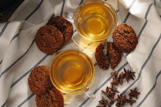 Dos tazas de té de hierbas y galletas en un paño de cocina