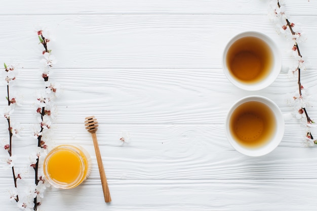 Foto dos tazas de té y miel sobre fondo de madera