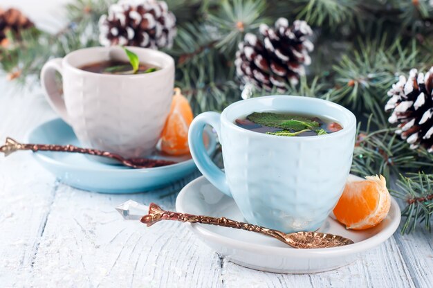 Dos tazas de té y rodajas de árbol de navidad mandarina