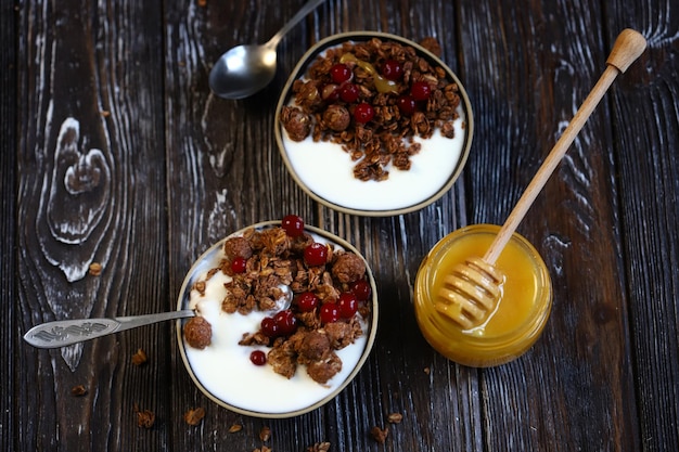 Dos tazones de desayuno con crujidos de miel, bayas y yogur.