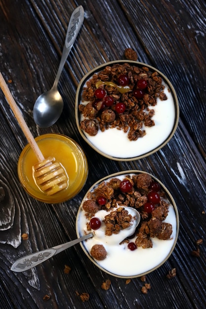 Dos tazones de desayuno con crujidos de miel, bayas y yogur.