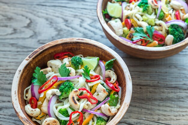 Dos tazones de pollo con fideos salteados