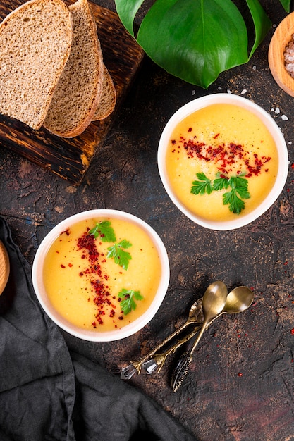 Dos tazones de sopa de puré de guisantes sobre fondo oscuro