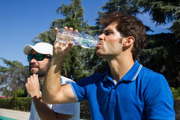 Dos tenistas profesionales hidratados después de un duro partido
