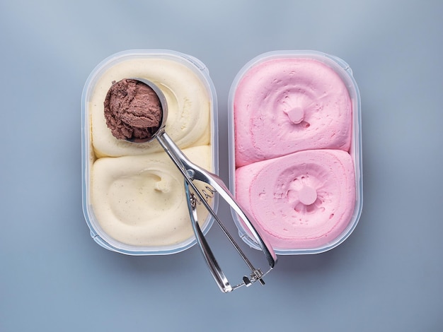 Dos tinas de helado con una cuchara aislada en un fondo claro