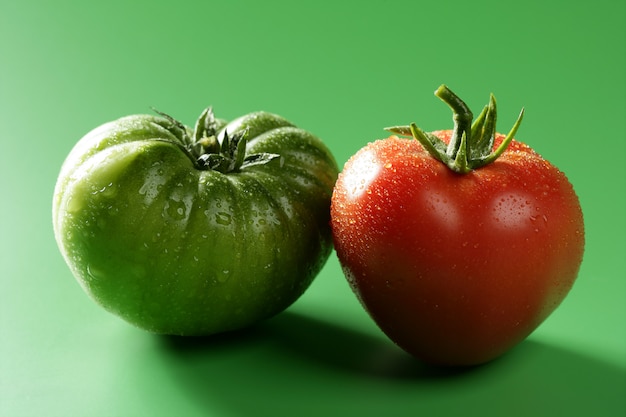 Foto dos tomates de color, variedad verde y rojo.