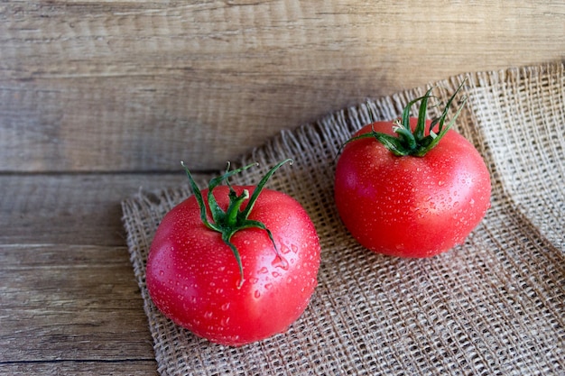 Dos tomates rosados en estilo rústico. Cosecha de tomates
