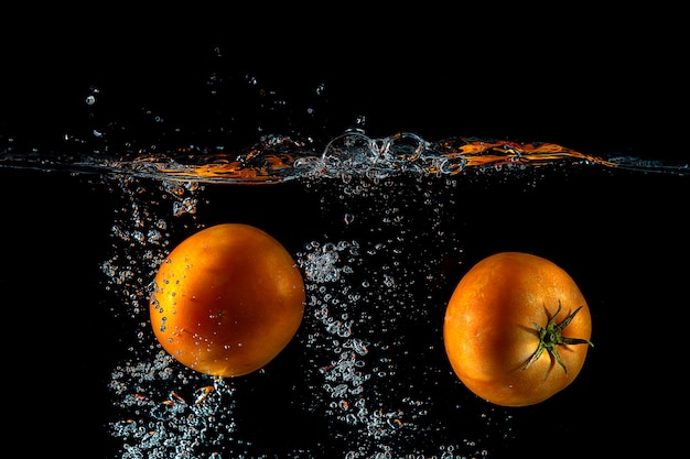 dos tomates salpican sobre el agua