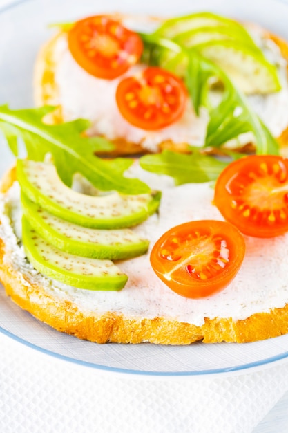 Dos tostadas con aguacate y rúcula en un plato