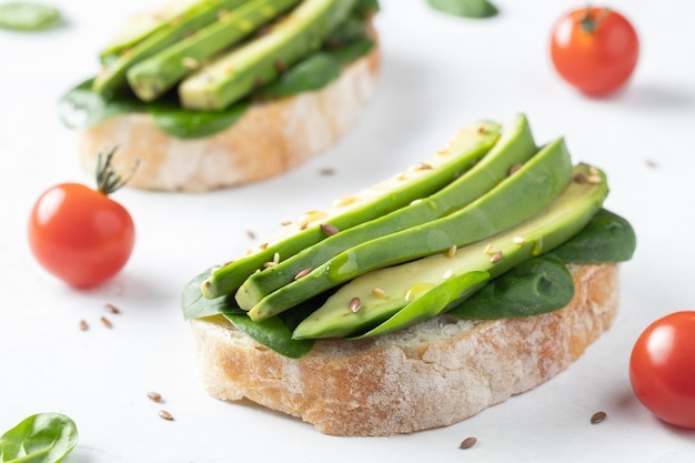 Dos tostadas ciabatta con aguacate en rodajas.