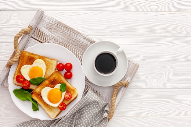 Dos tostadas con huevos revueltos en forma de corazón en un plato