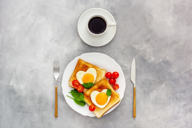 Foto dos tostadas con huevos revueltos en forma de corazón en un plato