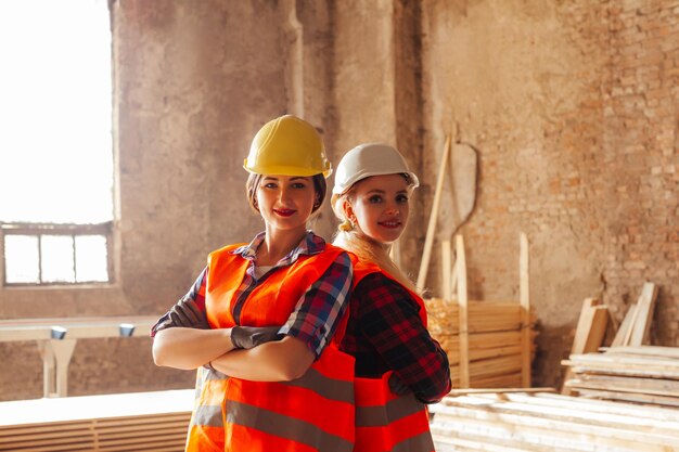 Foto dos trabajadoras con chalecos protectores amarillos y cascos