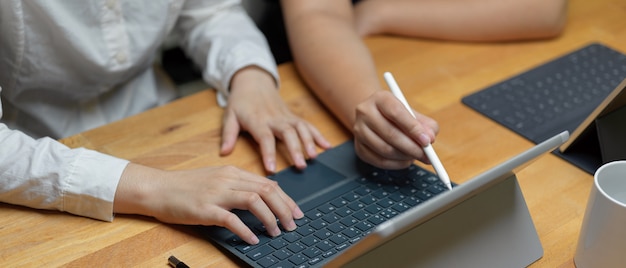 Dos trabajadoras discutiendo sobre su proyecto mientras trabajan con tableta