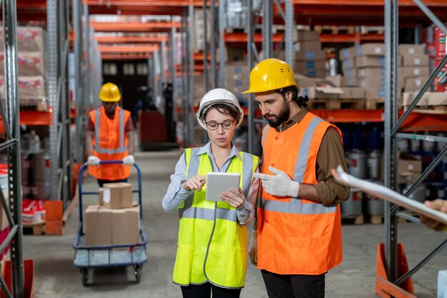 dos personas ingeniero masculino mano de obra personal empleado usar  uniforme amarillo casco casco seguridad hablar hablar discusión cuaderno  tableta informe información importación exportación envío logística carga  persona trabajo en equipo 18932630