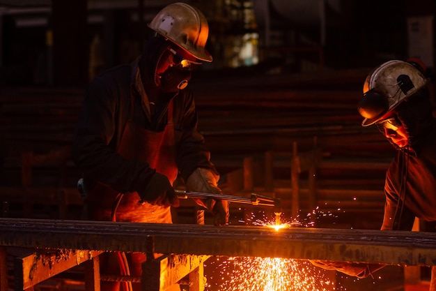 Dos trabajadores cortando acero con un soplete de oxiacetileno industrial