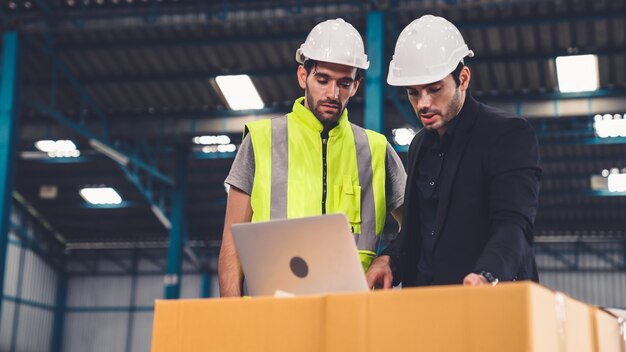 Dos trabajadores de la fábrica trabajando y discutiendo el plan de fabricación en la fábrica.