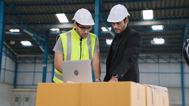 Dos trabajadores de la fábrica trabajando y discutiendo el plan de fabricación en la fábrica.