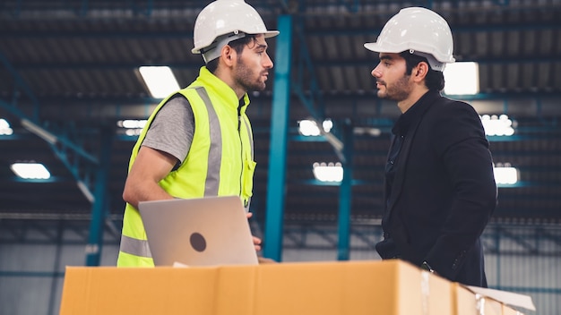 Dos trabajadores de la fábrica trabajando y discutiendo el plan de fabricación en la fábrica.