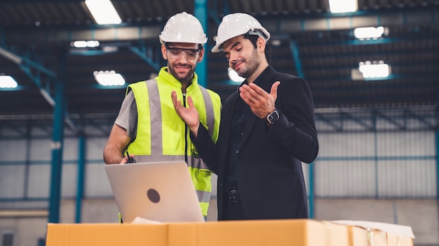 Dos trabajadores de la fábrica trabajando y discutiendo el plan de fabricación en la fábrica.