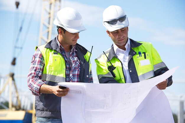 Dos trabajadores leyendo un plan.