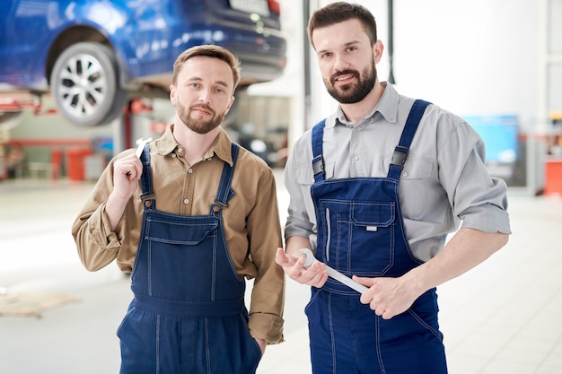 Dos trabajadores posando en la tienda de servicio de automóviles