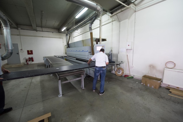 dos trabajadores que trabajan en una fábrica para la producción de muebles de madera