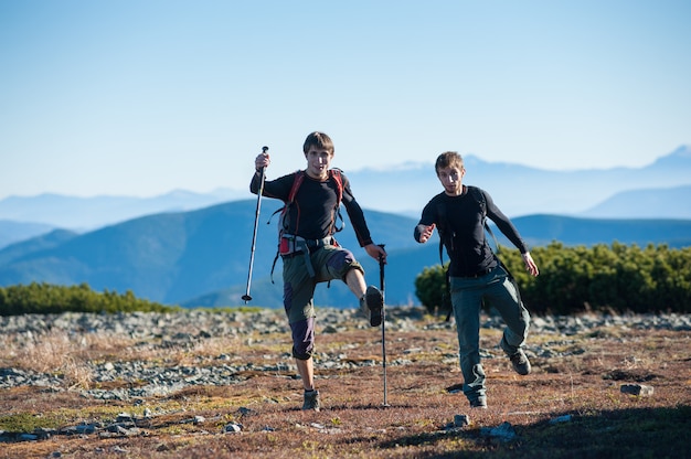 Dos turistas divirtiéndose en la cima de la montaña