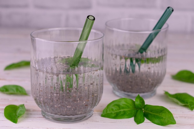 Dos vasos de agua con albahaca y semillas de chía. Bebida para bajar de peso.