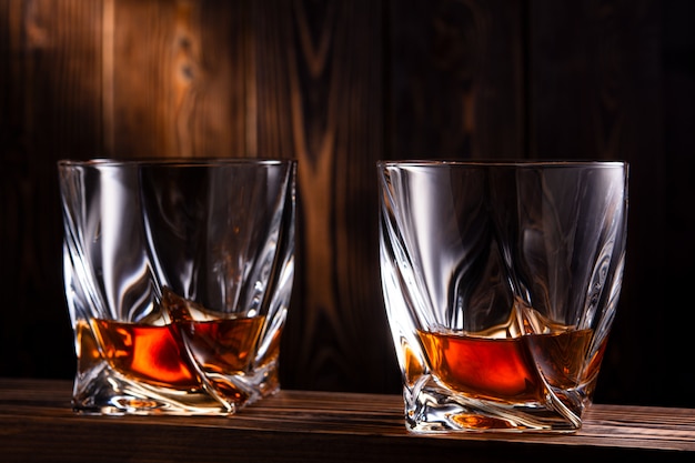 Dos vasos de alcohol en una pared de madera.