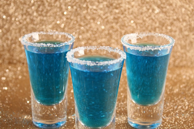 Dos vasos con bebidas alcohólicas azules Sobre un fondo dorado brillante