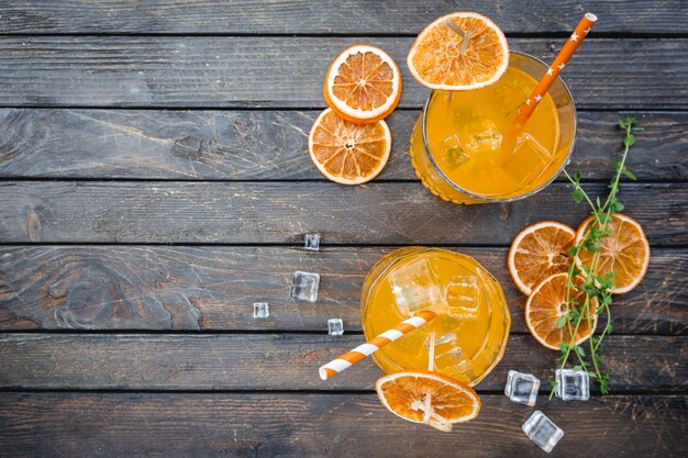 Dos vasos de cóctel de soda aperol con cubitos de hielo sobre la oscuridad