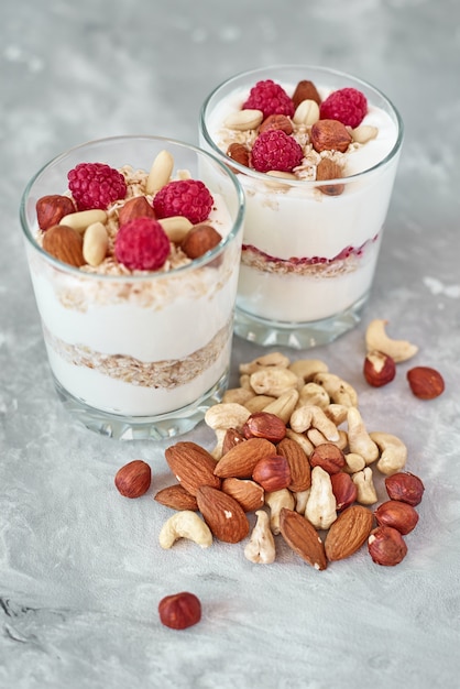 Dos vasos de granola de yogurt griego con frambuesas