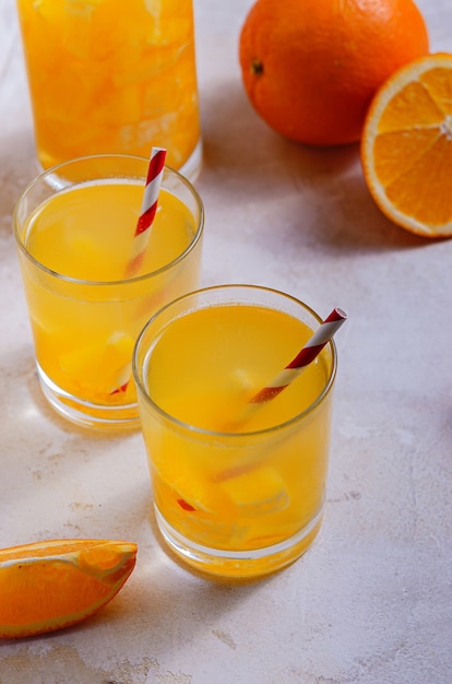 Dos vasos de limonada de naranja casera. Estilo rústico, comida sencilla y ligera. Cóctel de vitaminas