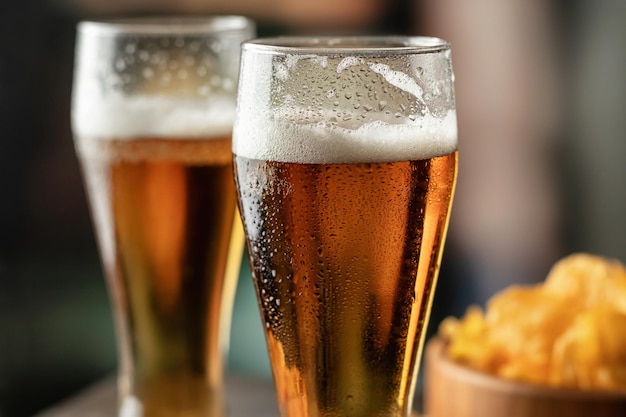 Dos vasos llenos de cerveza ligera con gotas en el lateral del bar de cerca Entretenimiento con alcohol bebidas tradicionales Concepto de ambiente de Oktoberfest Espacio de copia