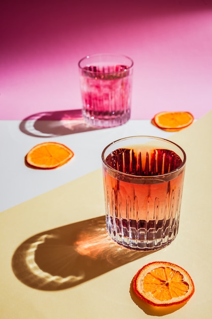 Dos vasos de rocas con bebidas con jarabe rojo