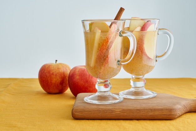 Dos vasos de sidra de manzana. Bebida caliente de invierno con canela, cardamomo y clavo, naranja