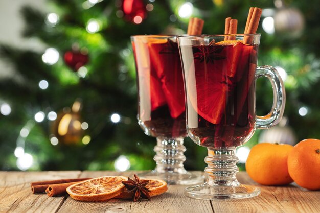 Dos Vasos De Vino Caliente Con Especias De Navidad O Gluhwein Con Especias Y Rodajas De Naranja En La Mesa Rústica Contra El Fondo Blanco.