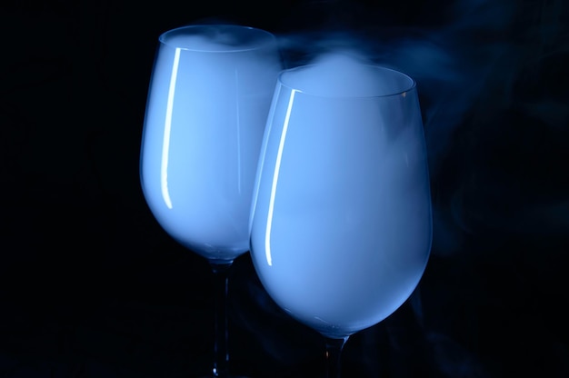 Dos vasos con vodka y martini cubiertos de humo blanco.