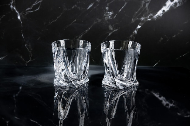 Foto dos vasos de whisky vacíos sobre fondo negro copiar espacio