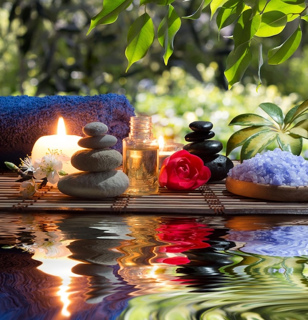 dos velas y toallas piedras blancas y negras y flores de almendra en el agua