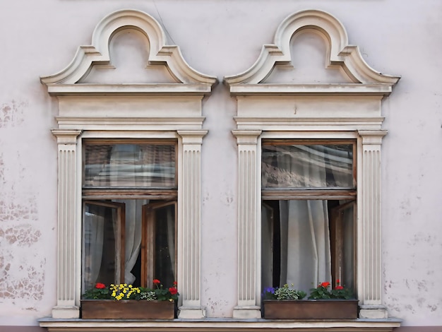 Dos ventanas abiertas con flores.