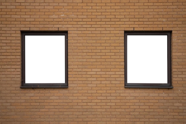 Dos ventanas en blanco con marcos de madera sobre fondo de pared de ladrillo naranja